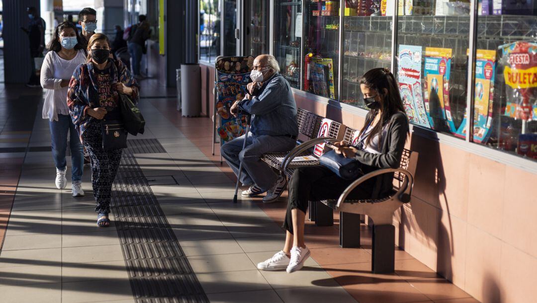Varias personas con mascarilla.