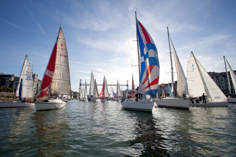 Barcos participantes en la Regata del Gallo navegan bajo el Puente Colgante