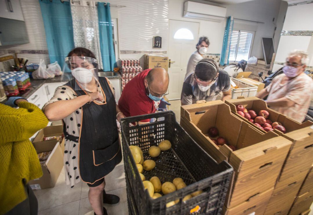 Reparto por parte de voluntarios de alimentos en el barrio del Cementerio.