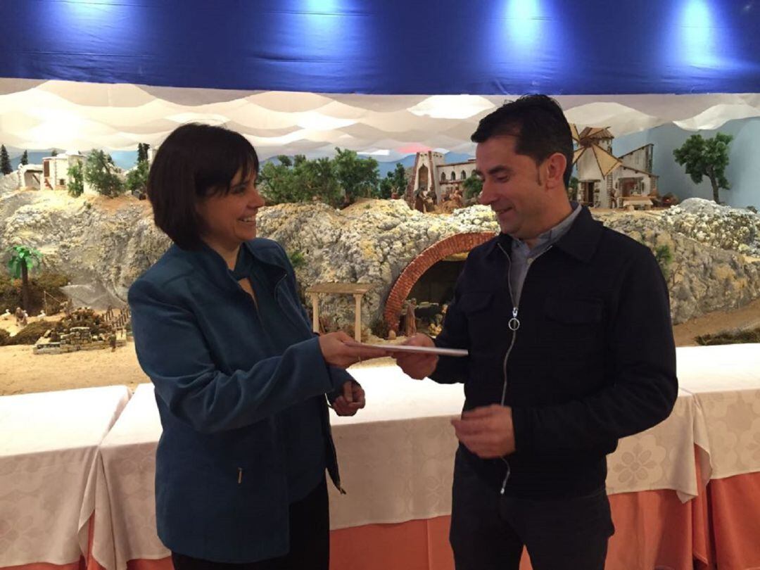 La directora de Montermoso, Gloria Herrero, entrega la donación correspondiente a la merienda solidaria de UNAE Aranda al presidente de Cruz Roja en la localidad, Agustín Escudero