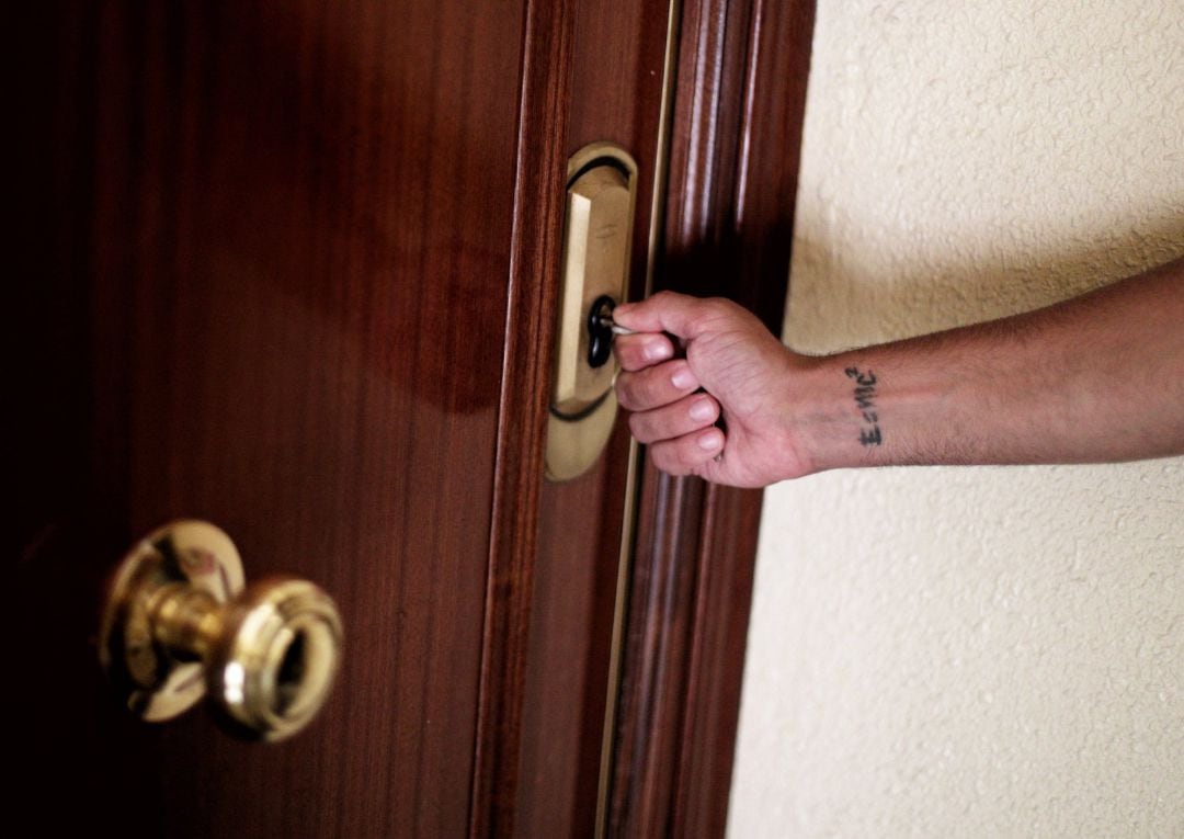 Archivo - Un hombre introduce una llave en la cerradura de la puerta de una vivienda.