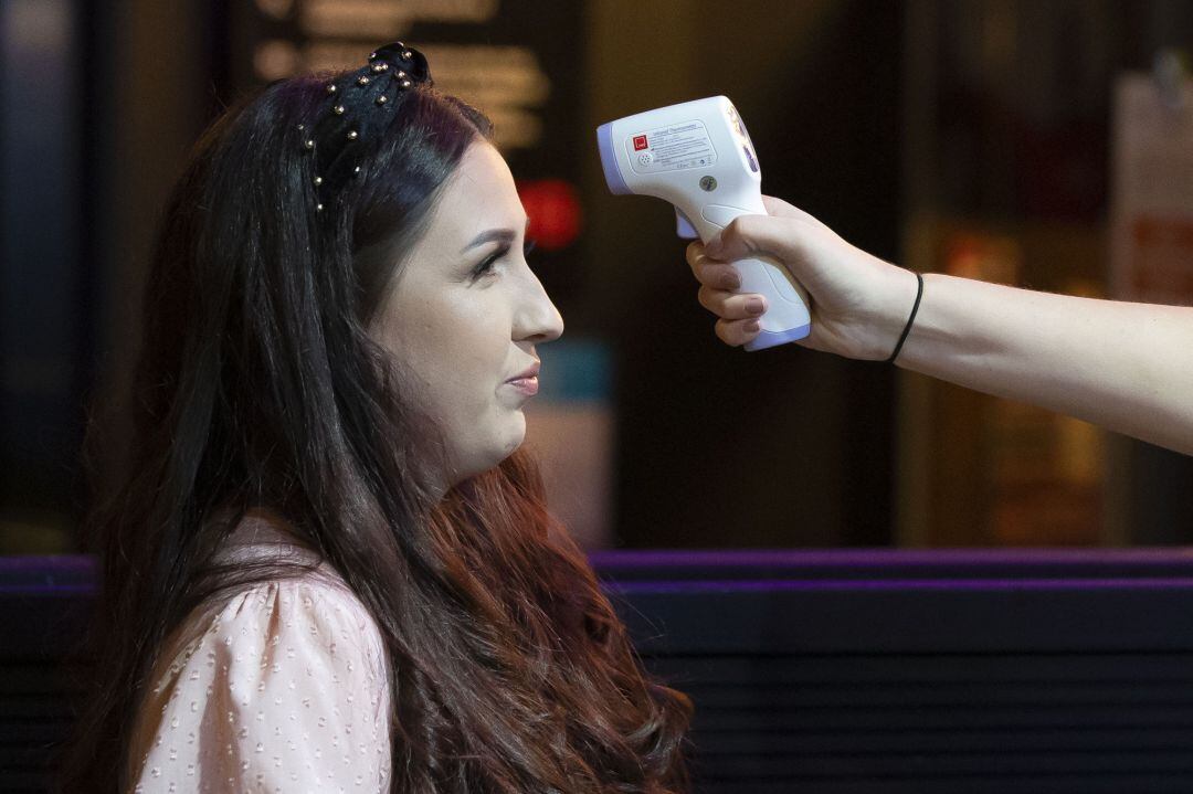 Toma de temperatura a una persona para detectar si tiene fiebre, uno de los síntomas del coronavirus.