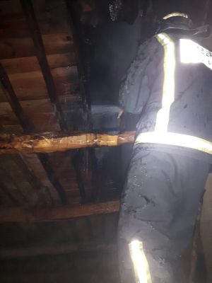 Bomberos trabjando en la estructura de madera