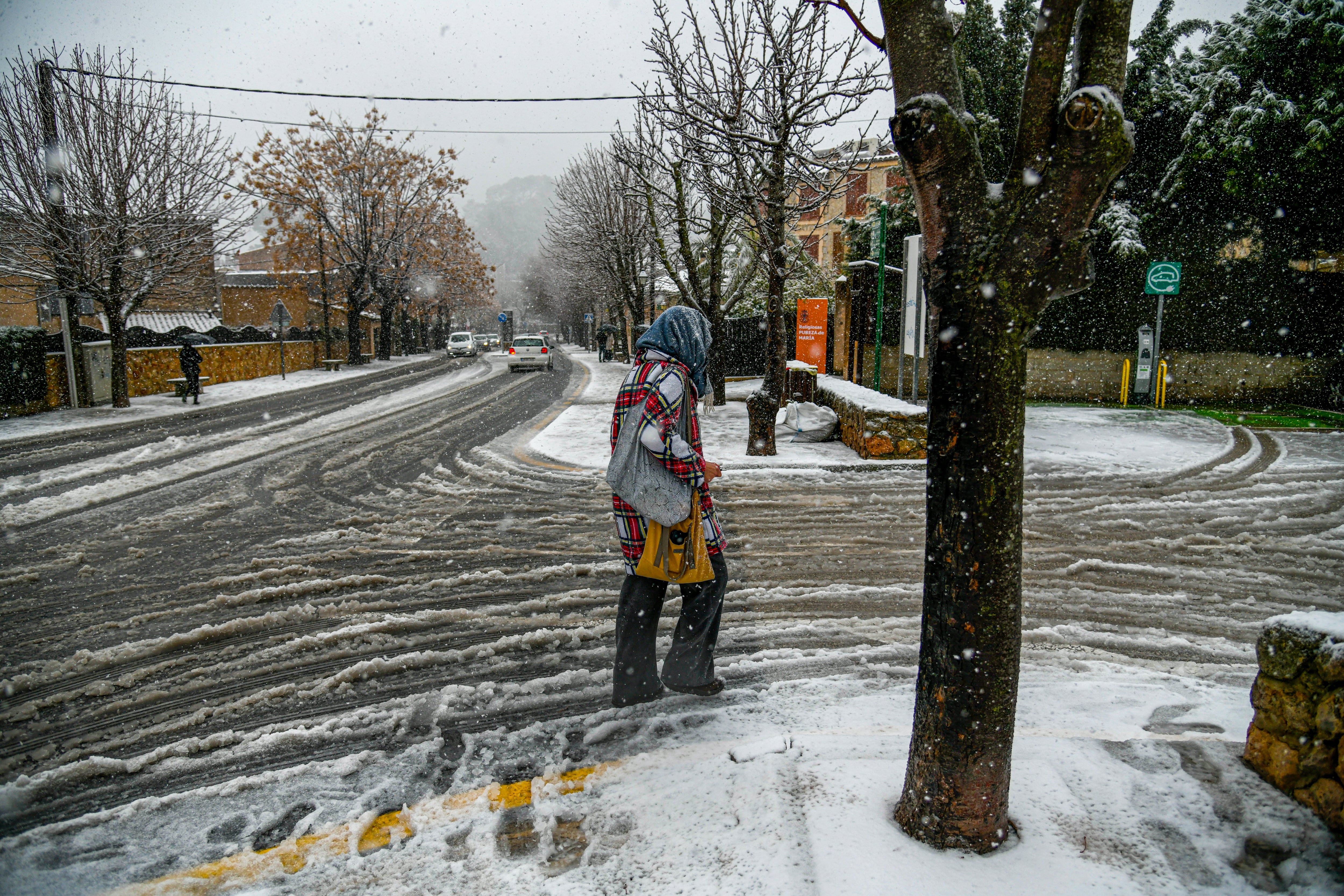 VALLDEMOSSA (ISLAS BALEARES), 27/02/2023.- Una mujer intenta caminar por las calles nevadas en la región mallorquina de Valldemossa La Agencia Estatal de Meteorología (Aemet) prevé para este lunes en Baleares cielos nubosos o cubiertos con precipitaciones que pueden ser fuertes y persistentes, e ir acompañadas de tormenta y de granizo pequeño. EFE/CATI CLADERA
