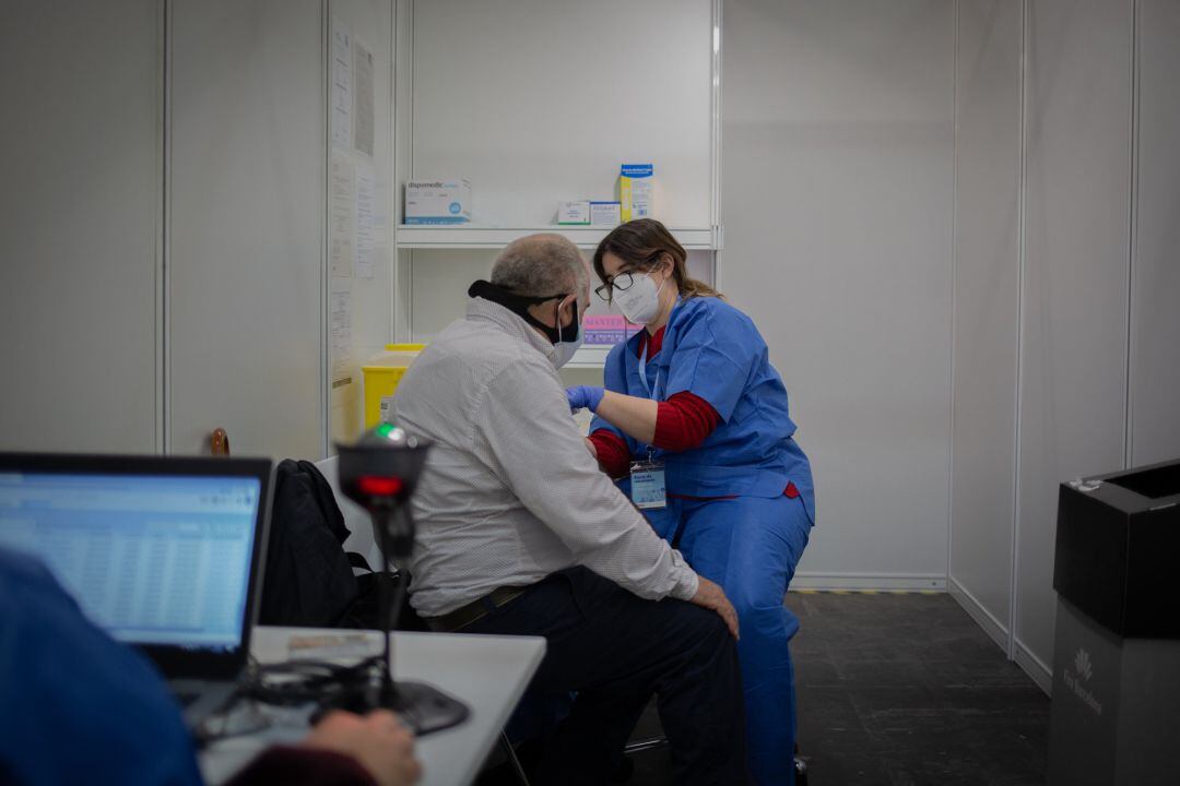 Una sanitaria vacuna a un hombre en el circuito de vacunación de Fira de Barcelona, a 26 de abril de 2021.