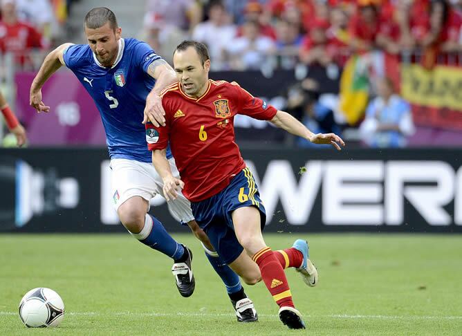 El jugador de la selección española Andrés Iniesta lucha por un balón con el internacional italiano Thiago Motta, durante el partido de la Eurocopa 2012 correspondiente al Grupo C entre las selecciones de España e Italia, en Gdansk, Polonia, el domingo 10