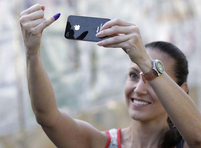 Una venezolana toma una foto de su dedo manchado de tinta después de votar.
