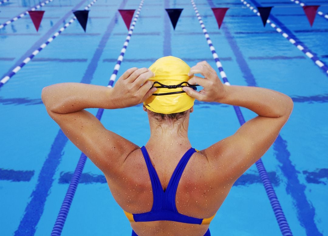 Imagen de una nadadora al borde de una piscina de competición