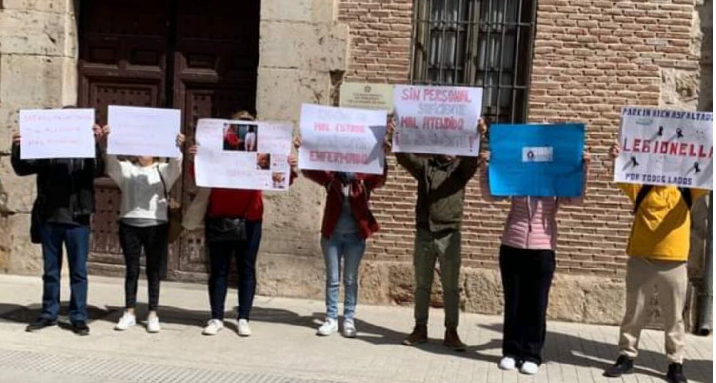 Familiares de mayores de la residencia Francisco de Vitoria con carteles de denuncia sobre la situación del centro.