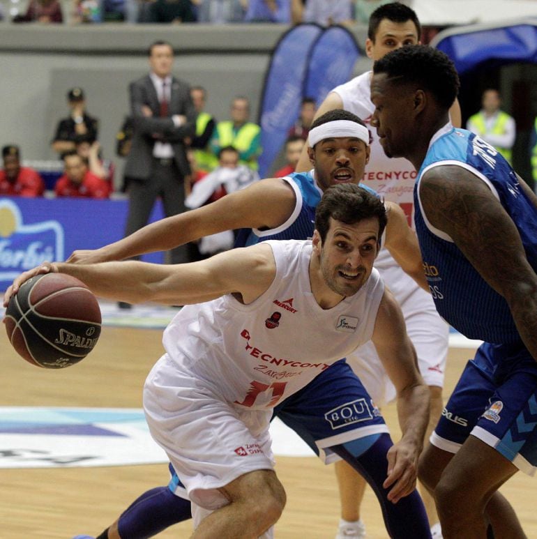 El base del Zaragoza, Tomás Bellas (i), protege el balón ante la presencia del ala pívot estadounidense del San Pablo Burgos, Deon Thompson, durante el partido correspondiente a la jornada 31 de la Liga Endesa, disputado, este domingo, en Burgos. 