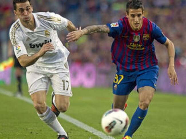 Christian Tello pelea un balón con el defensa del Real Madrid Alvero Arbeloa.