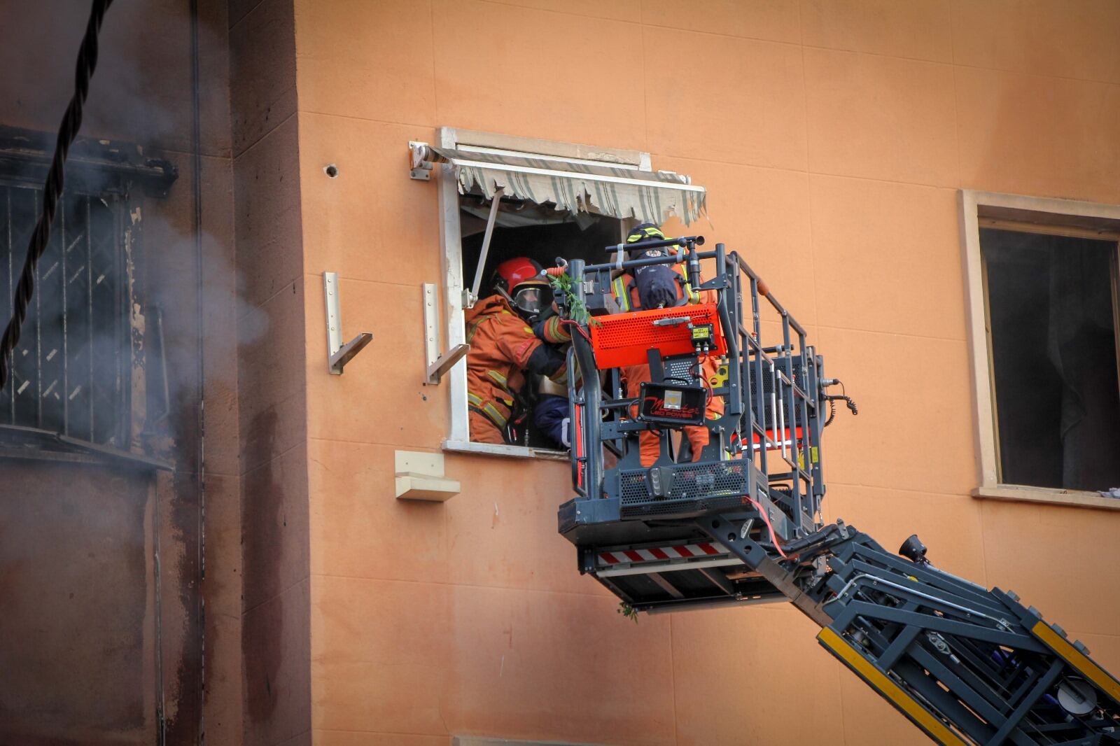 Los bomberos tratan rescatar a dos personas por un incendio en una finca de Torrent dañada por la DANA.