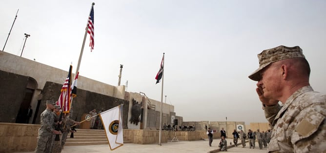 Los soldados americanos saludan su bandera en la ceremonia de retirada de sus tropas en Bagdad