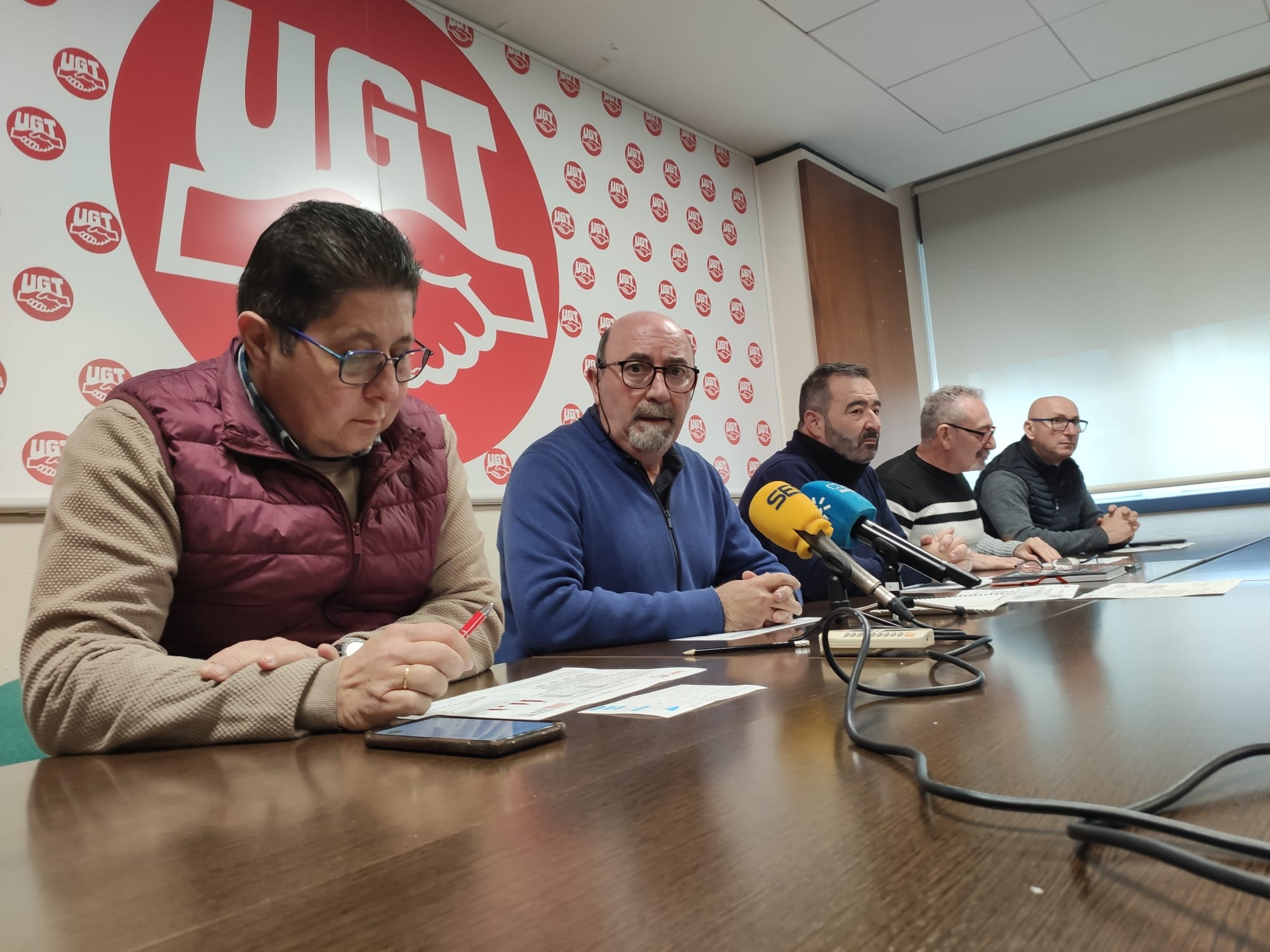 El secretario general de UGT en la provincia de Jaén, Manuel Salazar, mira a cámara rodeado por miembros del sindicato durante una rueda de prensa