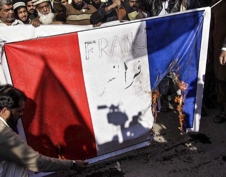 PES05 PESHAWAR (PAKISTÁN) 16/01/2015.- Simpatizantes de la organización benéfica ilegalizada Jamatud Dawa queman la bandera francesa durante una protesta contra la publicación de la caricatura de Mahoma en Charlie Hebdo celebrada hoy, viernes 16 de enero 