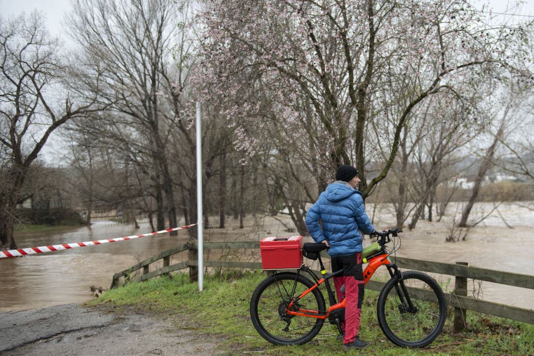 Un ciclista davant un Ter desbordat