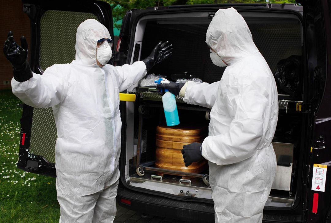  Trabajadores de un tanatorio de Pamplona desinfectan sus EPIs después de sacar del Hospital de Navarra un ataúd para proceder a su desinfección