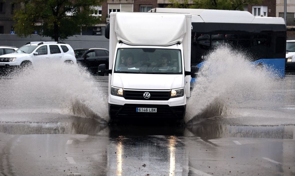 Un camión atraviesa un charco en Madrid.