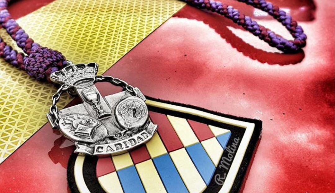 La medalla de la Hermandad de San Pablo, sobre el escudo de la UME