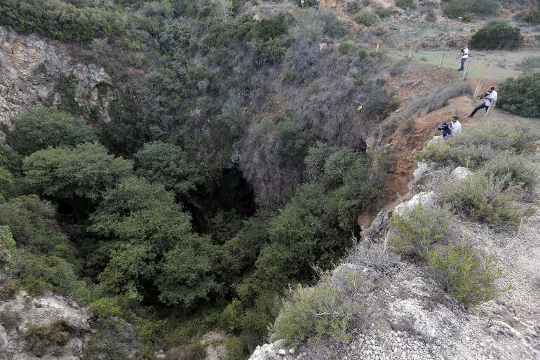 Varios cámaras de televisión toman imágenes de la sima donde agentes del Servicio de Protección de la Naturaleza (Seprona) han localizado el cadáver desnudo de una joven en las inmediaciones de la localidad valenciana de Chella