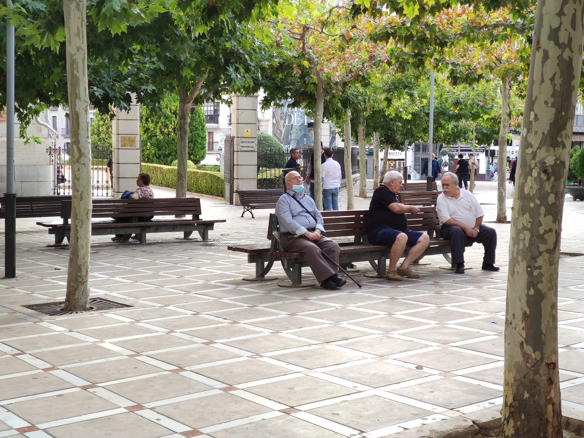 Algunas personas mayores sentadas en un banco de la Plaza de San Francisco de Jaén capital