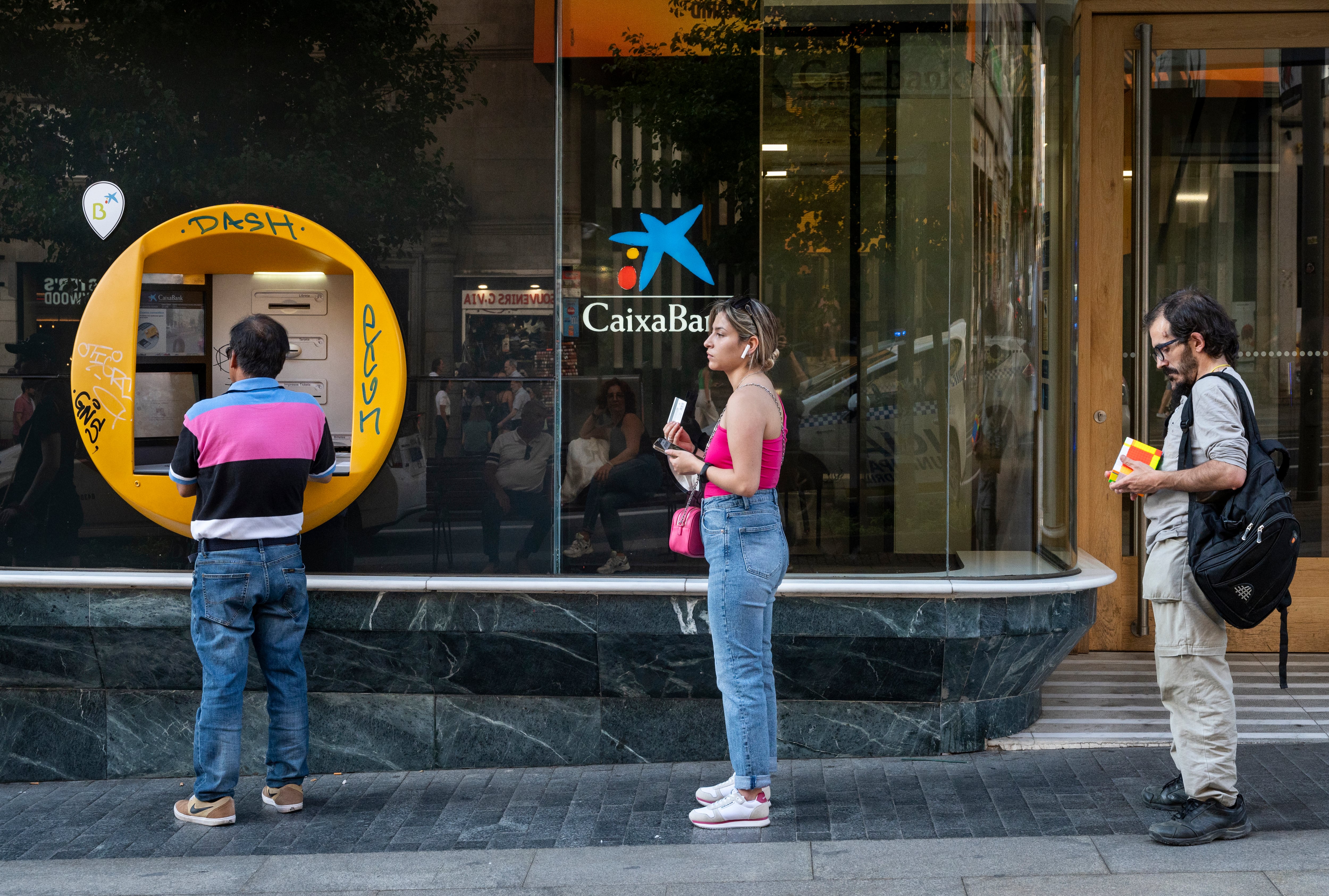 Varias personas frente a un cajero.