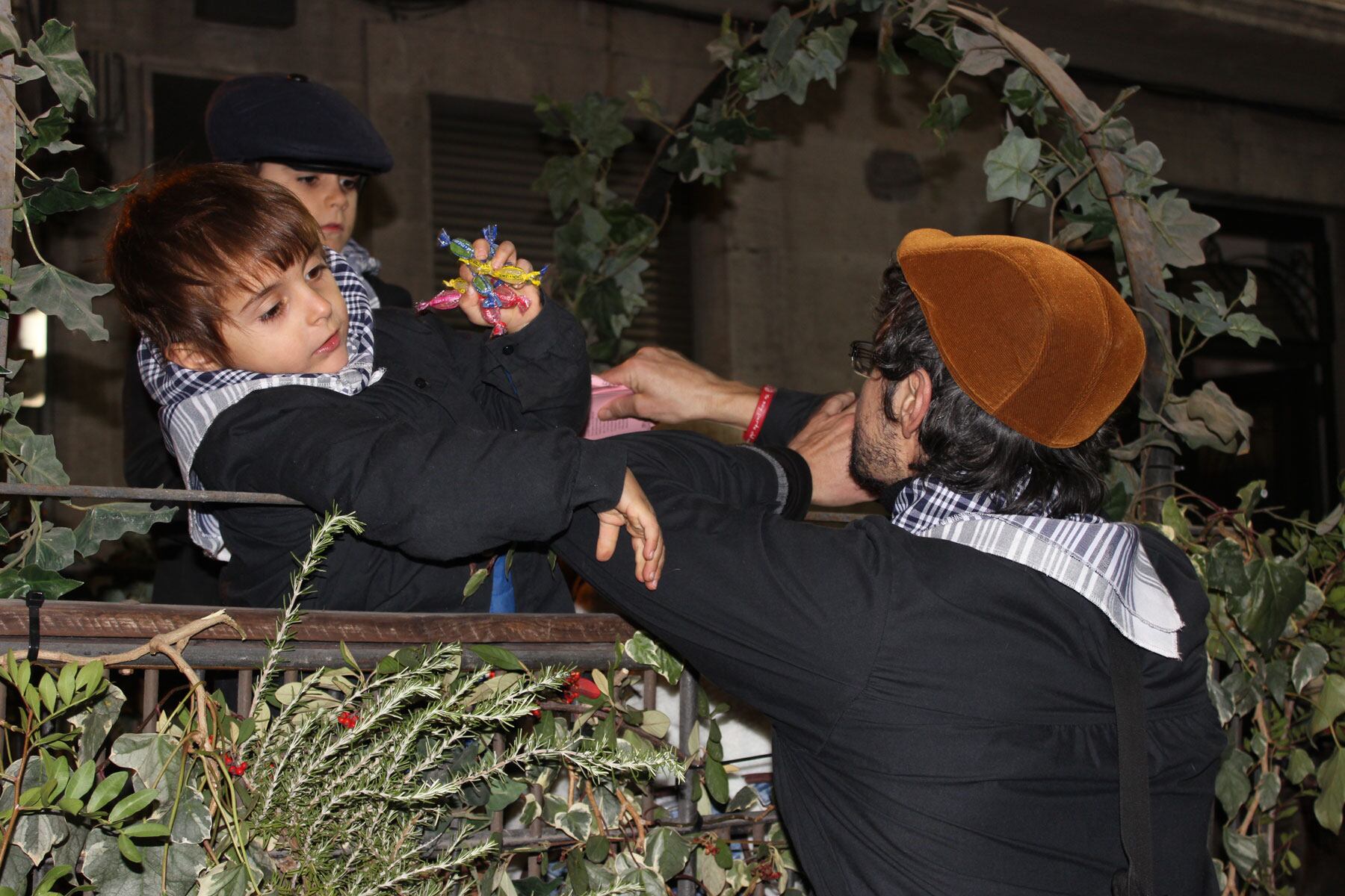 Un dels xicotets pastorets en un dels carros tirant caramels al públic
