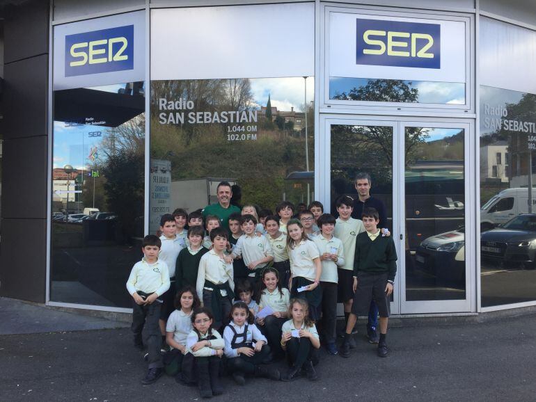 Los niños de 4º de Primaria del Colegio Inglés San Patricio posan con Porfi Fisac, técnico del Delteco GBC, en el exterior de las instalaciones de Radio San Sebastián