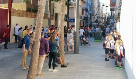 Niños y padres esperan en la calle el acceso a un colegio