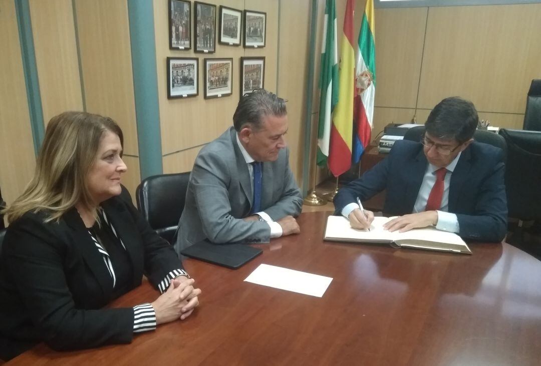 El vicepresidente de la Junta de Andalucía, Juan Marín, escribe en el libro de honor del Ayuntamiento de Linares, durante la reunión mantenida con el alcalde, Raúl Caro, y otros representantes de los gobiernos autonómico y municipal.