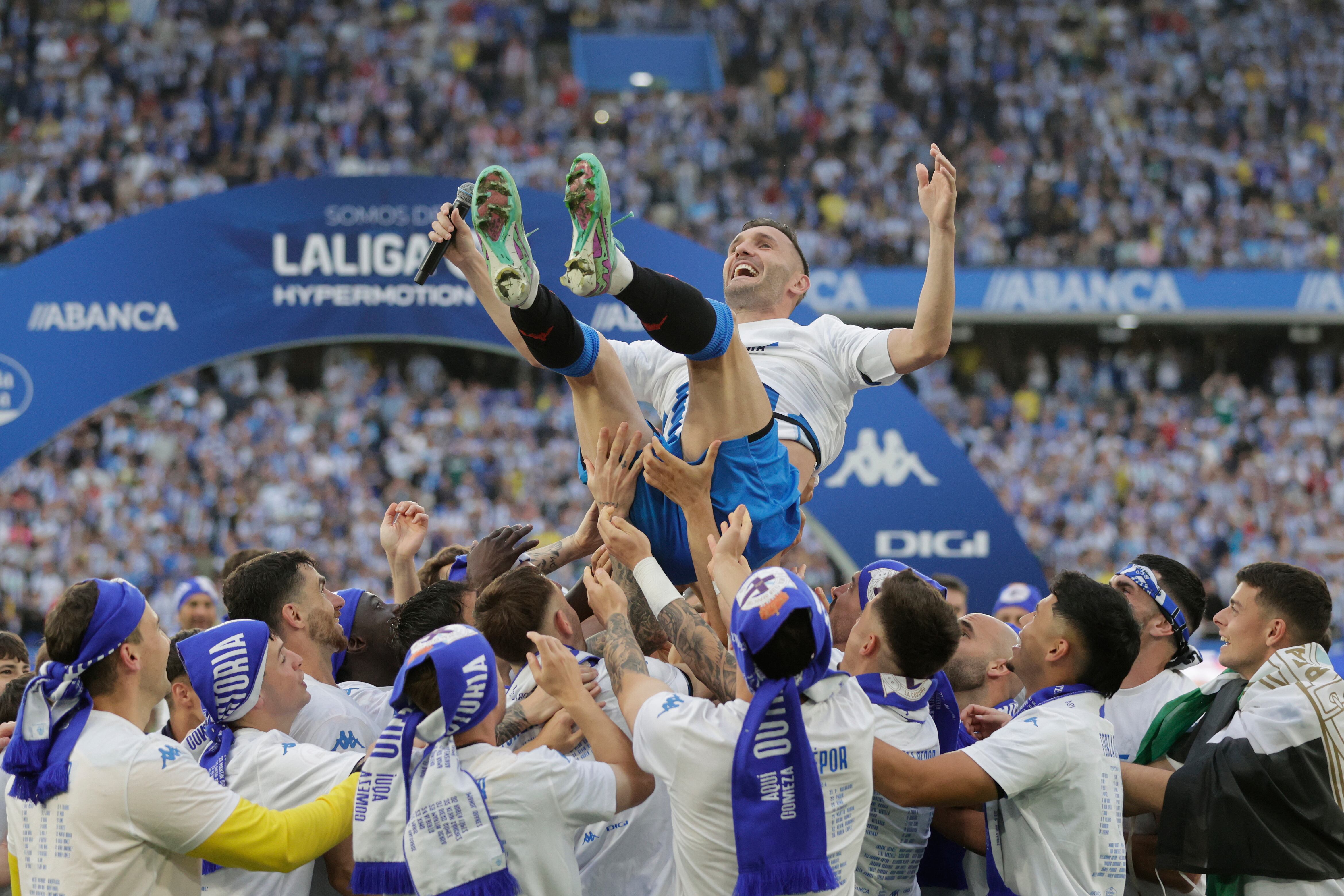 A CORUÑA, 12/05/24.- Los jugadores del Deportivo mantean a Lucas Pérez (c) durante la celebración del ascenso a Segunda División tras vencer al Barça Atlètic este domingo en el estadio de Riazor de A Coruña. EFE/Cabalar
