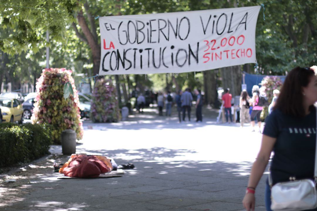 Una pareja durmiendo en un saco de dormir en el Paseo del Prado