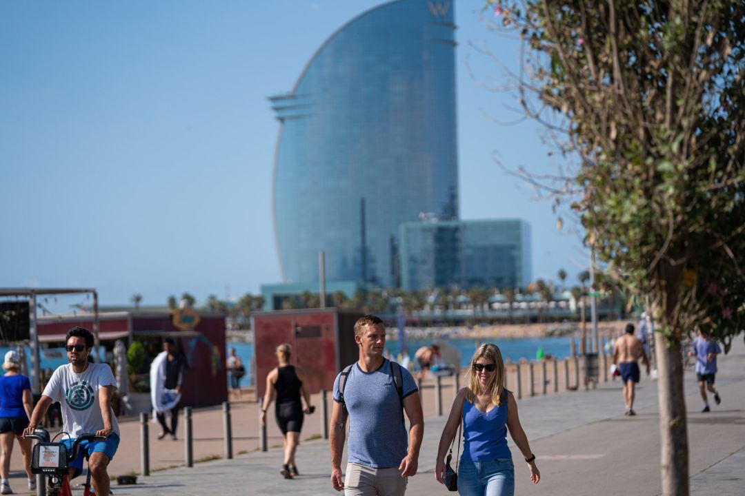 Una pareja pasea por la Barceloneta