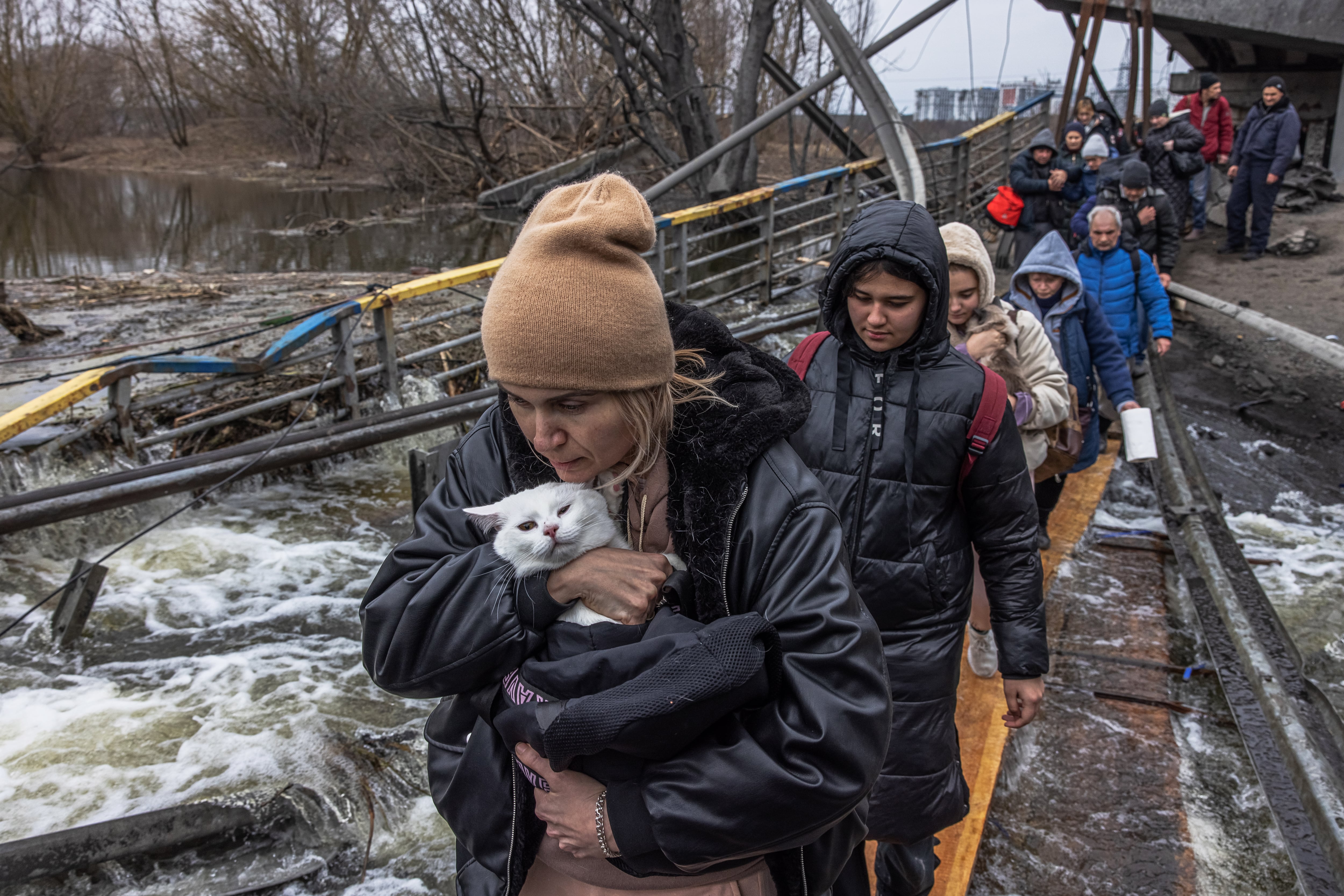 Varias personas cruzan por un puente derruido en la capital de Ucrania, Kiev