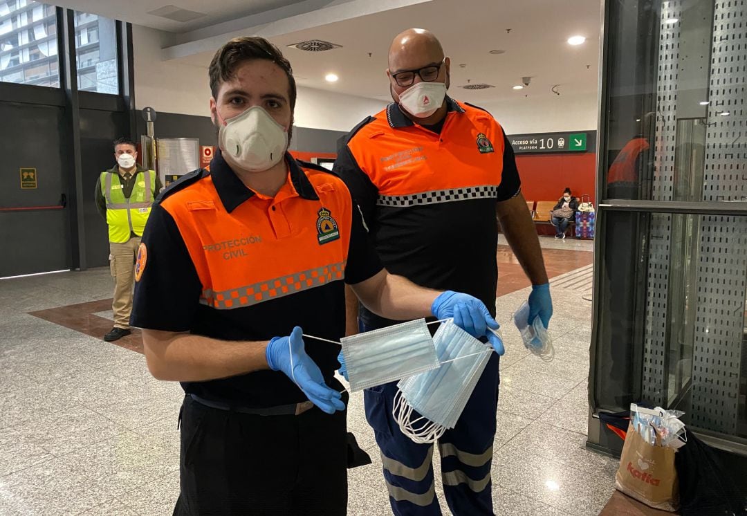 Voluntarios de Protección Civil realizan el reparto este lunes en la estación de cercanías de María Zambrano