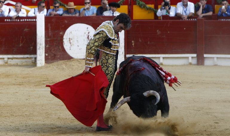 El diestro José Tomás da un pase con la muleta al primero de su lote, durante la corrida de la festividad de San Juan en la plaza de toros de Alicante