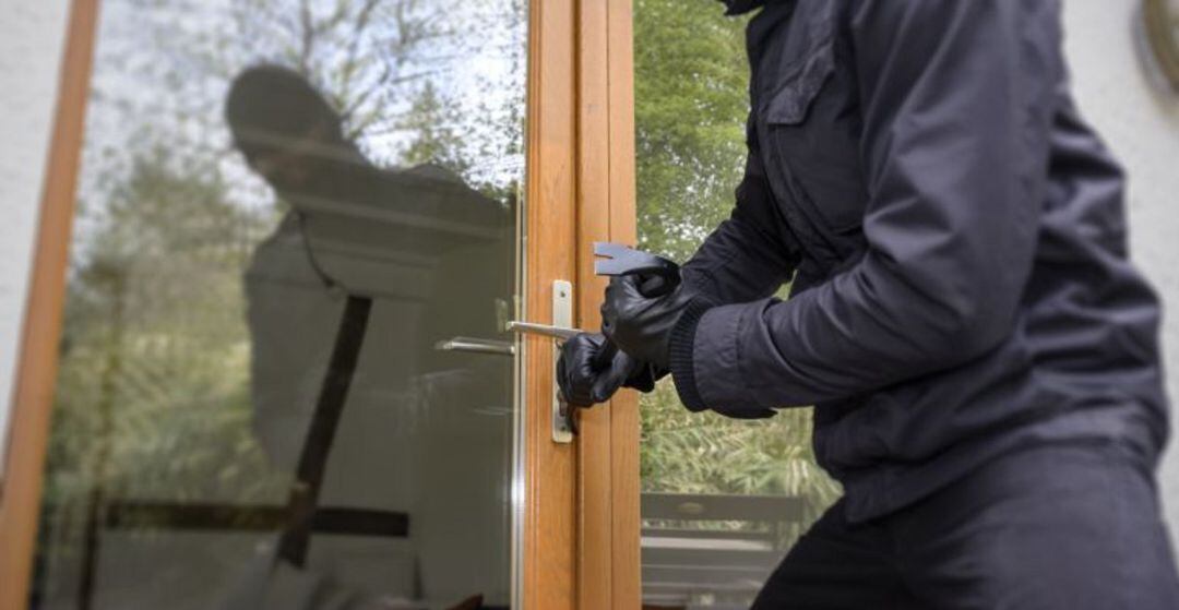 Un ladrón intenta forzar una puerta de un domicilio