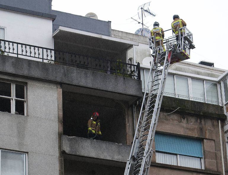 Los bomberos acceden a la vivienda de la calle San Salvador en Vigo, que  ha sufrido una explosión de gas y que ha causado la muerte de una persona