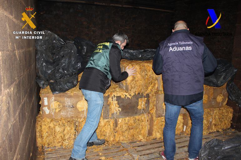 Miembros del servicxio de Aduanas de la Guardia Civil custodian la picadura de tabaco ilegal incautada a la trama navarra