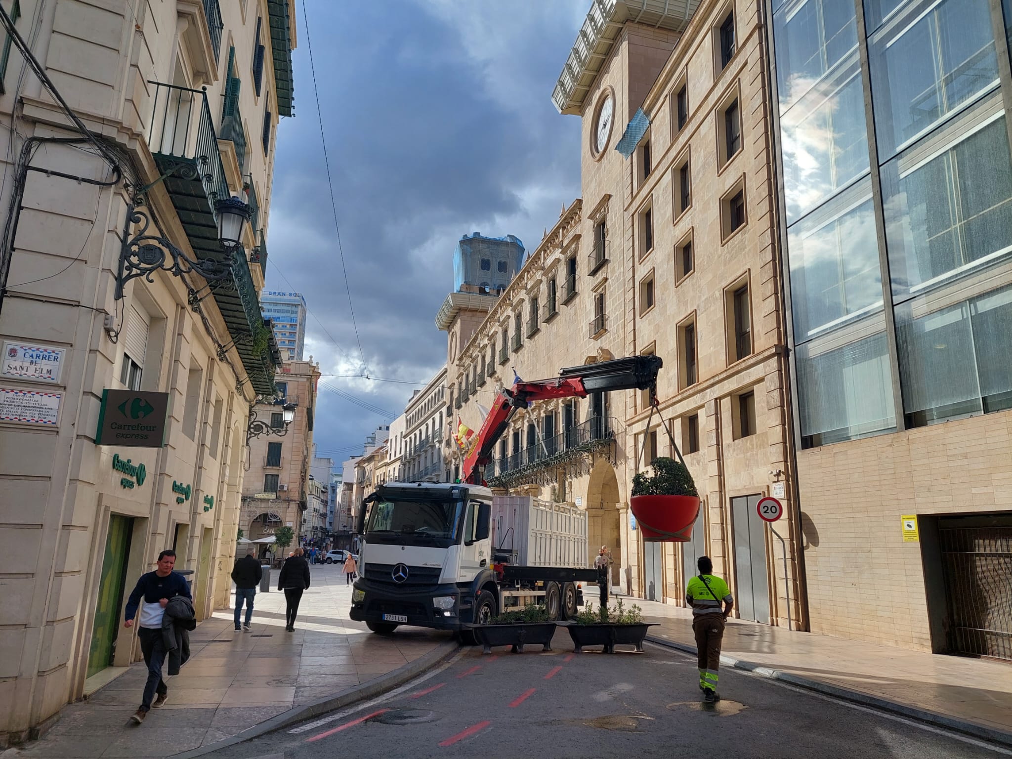 Los operarios municipales retiran los maceteros que impedían el paso de vehículos para proceder a la reapertura al tráfico de la plaza del Ayuntamiento de Alicante