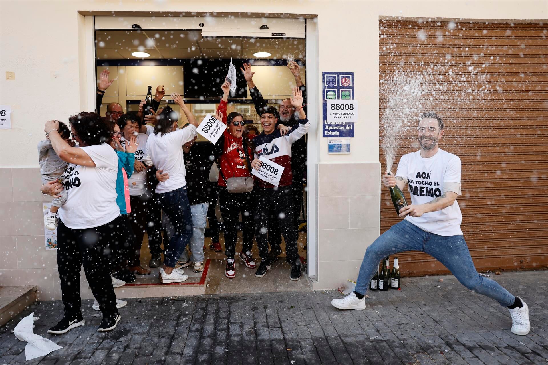 Vicente (a la derecha) celebrando a las puertas de su administración de lotería en Vilamarxant que habían dado El Gordo