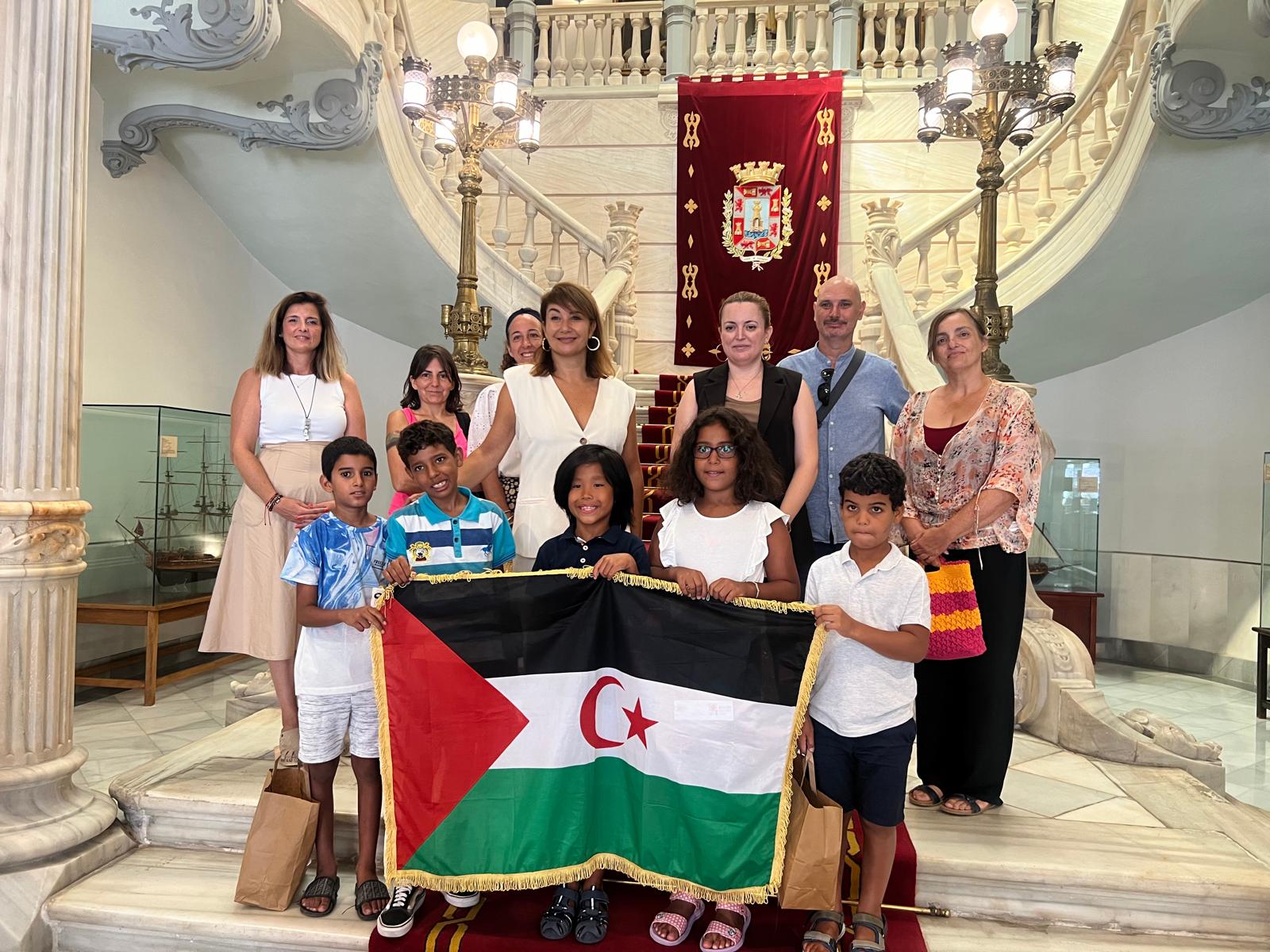 Foto de las familias y los niños de acogida con la Concejala Cristina Mora en las escalinatas del Ayuntamiento de Cartagena