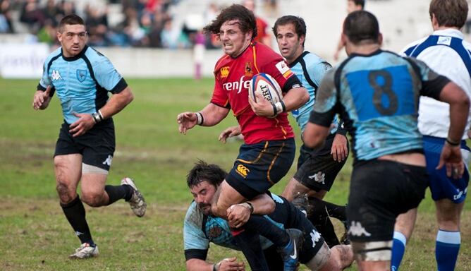 Glenn Rolls avanza entre jugadores de Uruguay