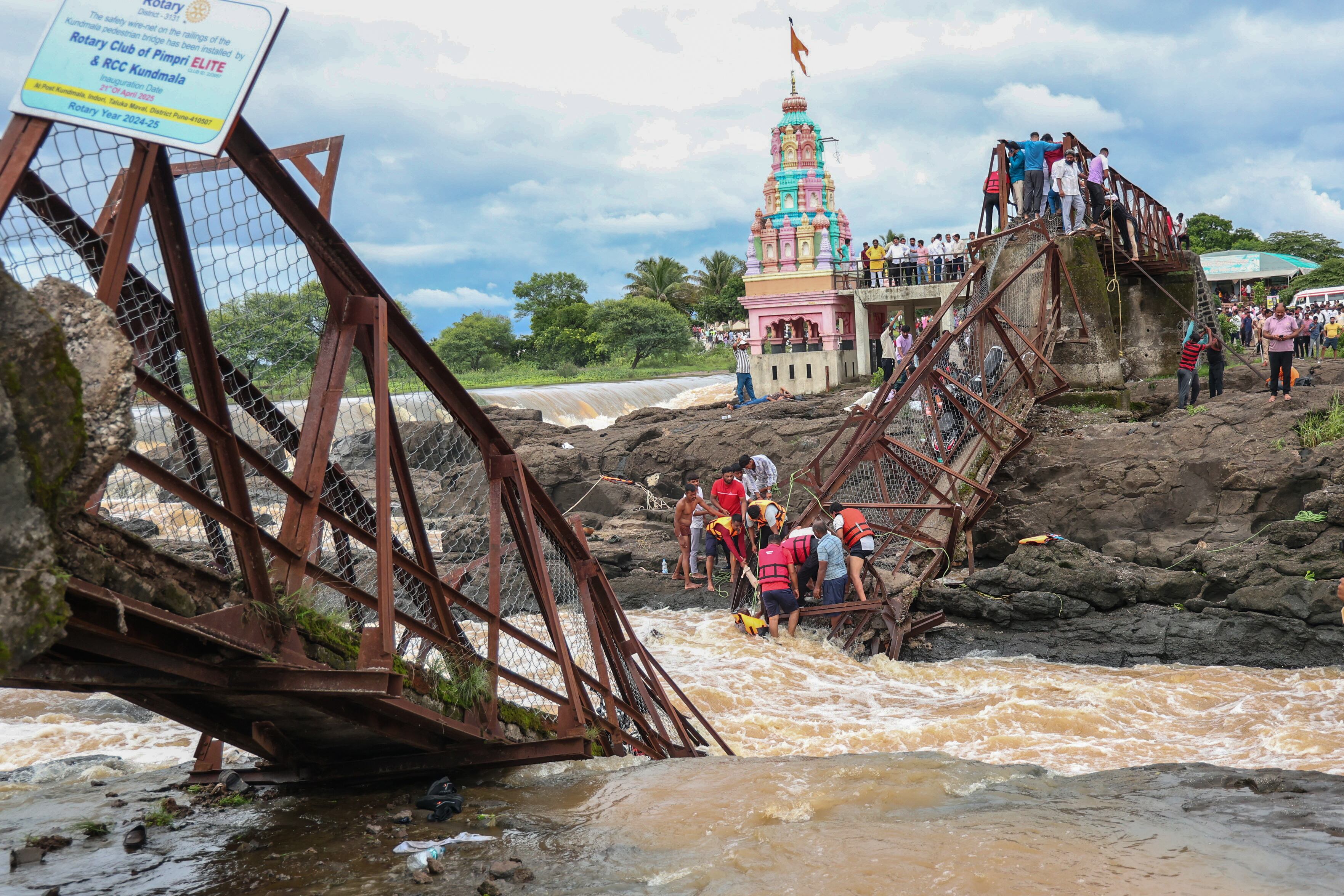 Equipos de rescate trabajan tras el colapso de un puente peatonal este domingo.