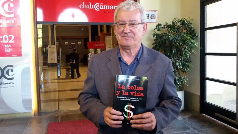 Josu Ugarte con un ejemplar de &quot;La bolsa y la vida. La extorsión y la violencia de ETA contra el mundo empresarial&quot;. El libro se ha presentado hoy en la Cámara de Comercio de Zaragoza 