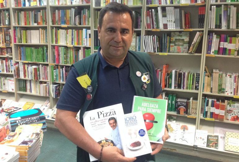 David García, de la sección de Gastronomía de la casa del Libro, posando con el libro más vendido, el que más se está vendiendo y el que más se va a vender.