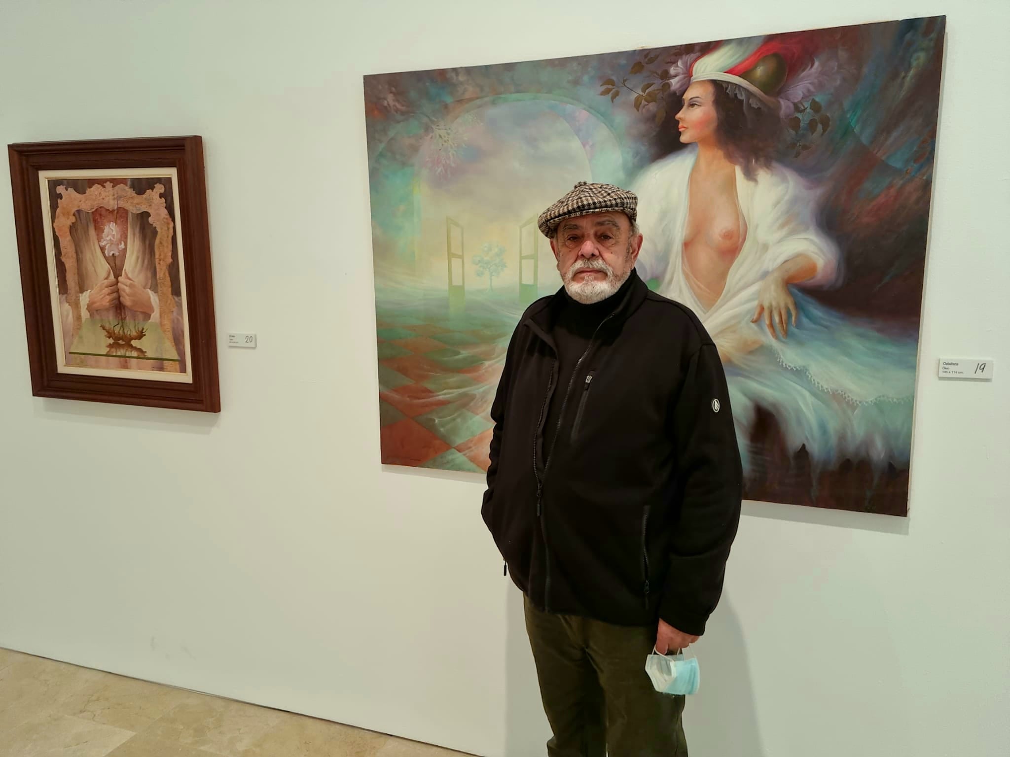 Cristóbal López posa ante dos de las obras expuestas en la muestra