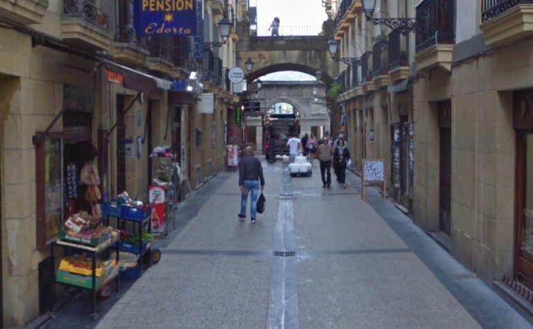 Vista de una calle de la Parte Vieja de San Sebastián con varias tiendas con productos en el exterior.