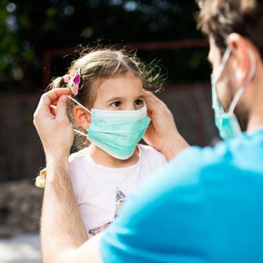 Colocando la mascarilla a una niña