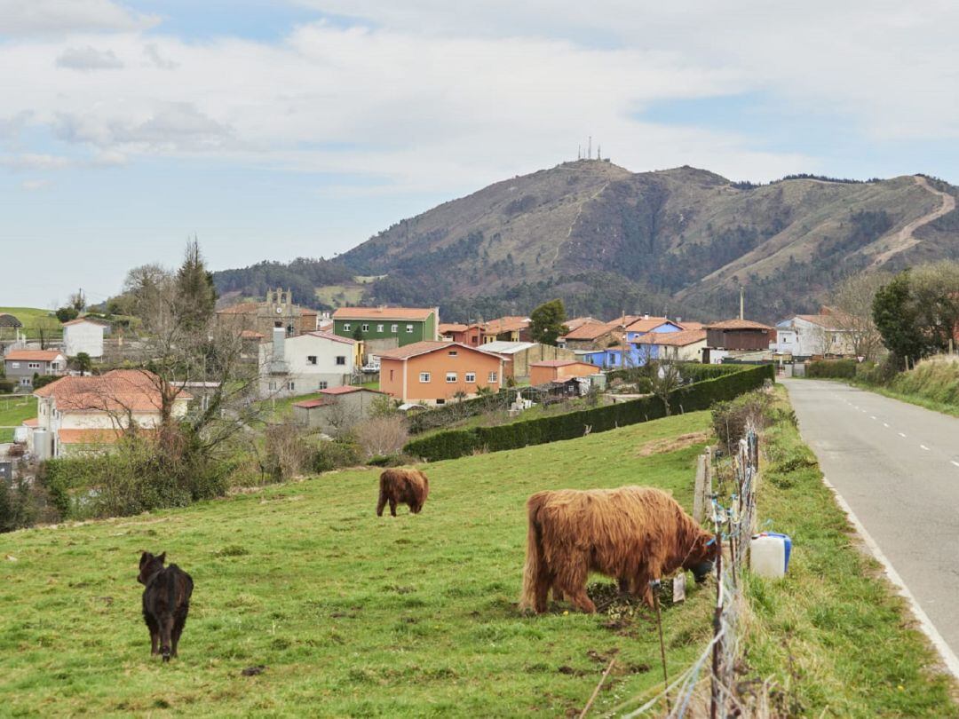 El monte, que aparece el fondo, domina el paisaje de este concejo